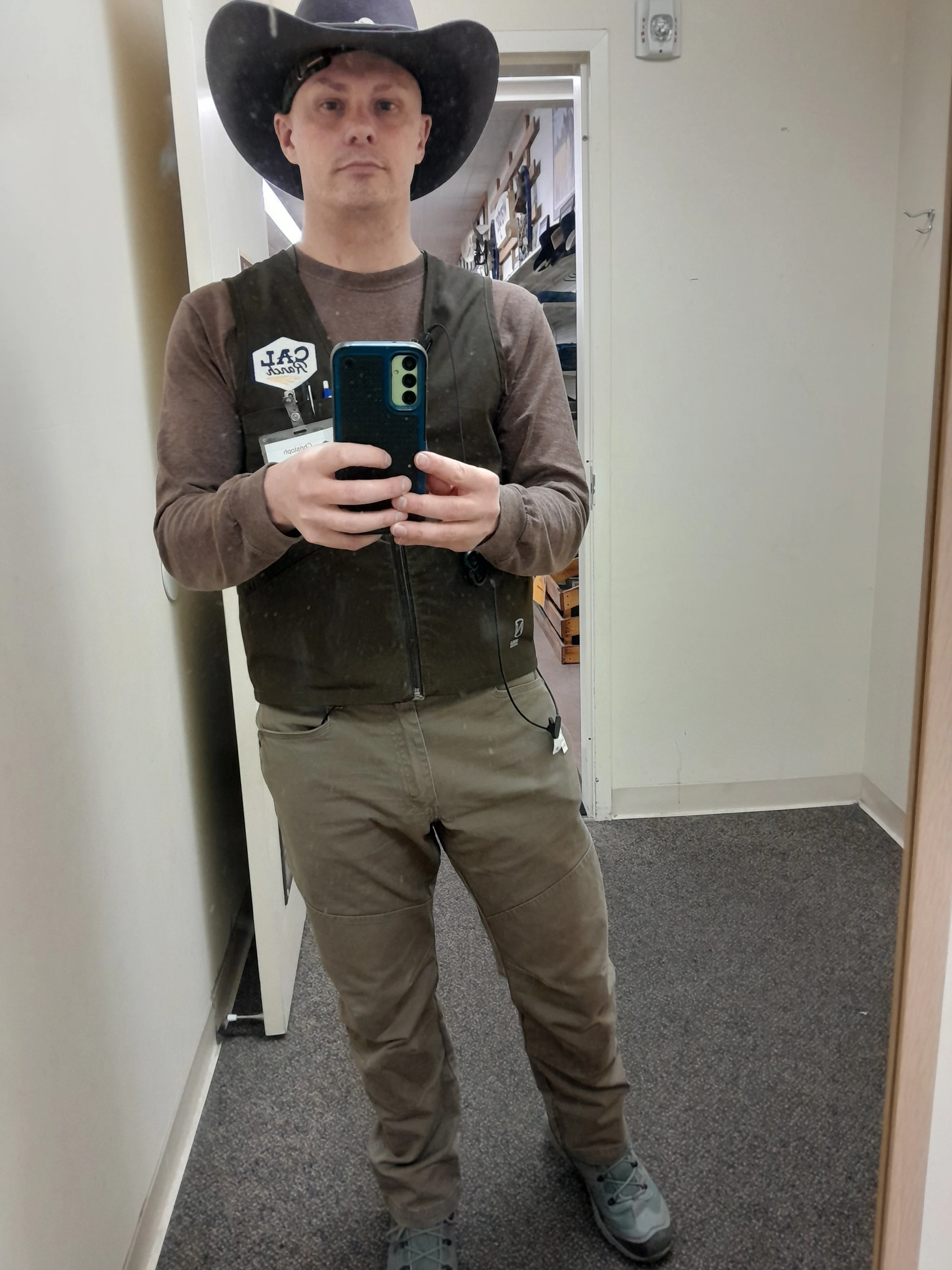 Portrait of Christopher Lazok wearing utility work vest with operational badge and western hat in Carson City, Nevada.